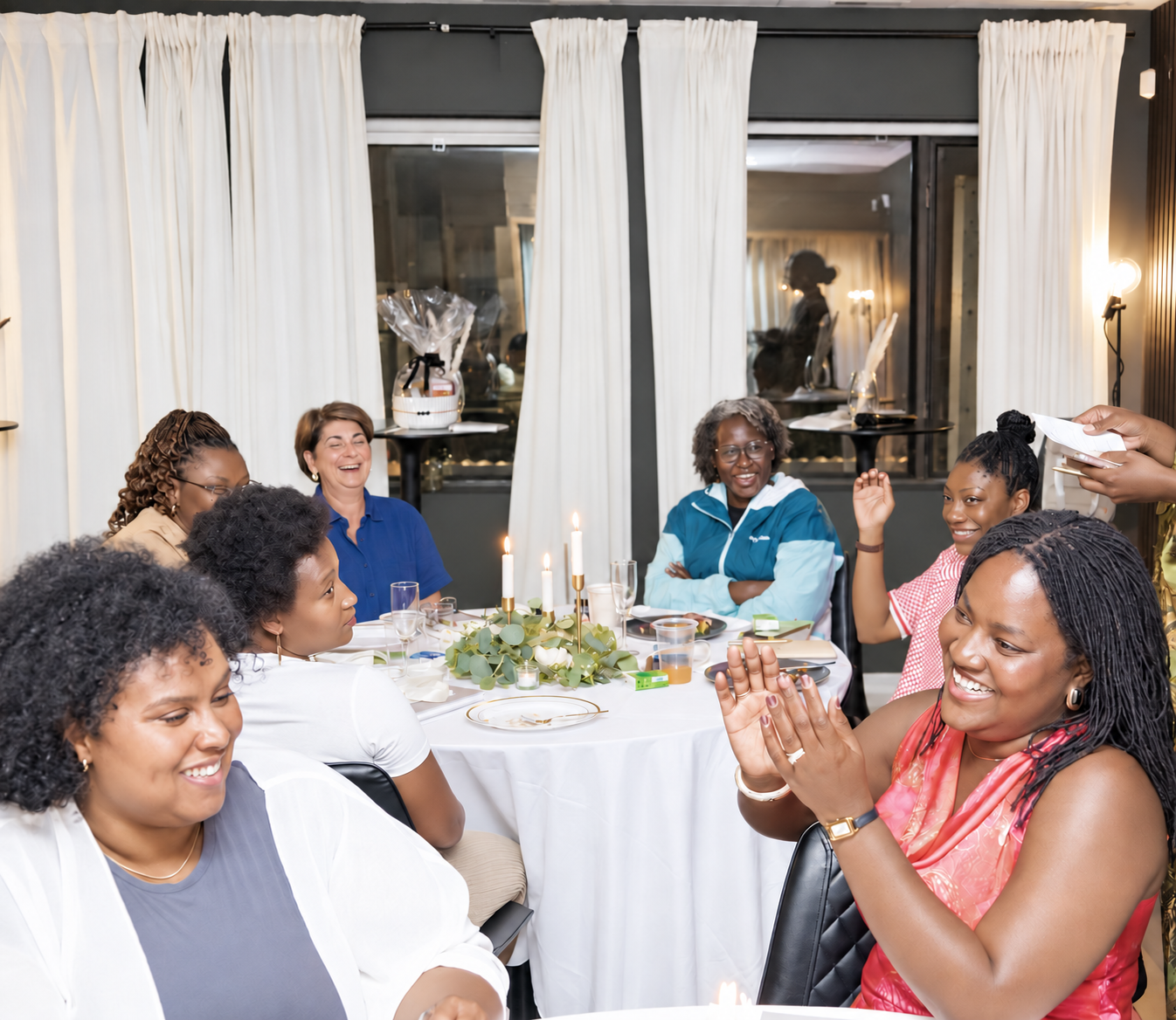 Women gathered around a table, laughing and connecting